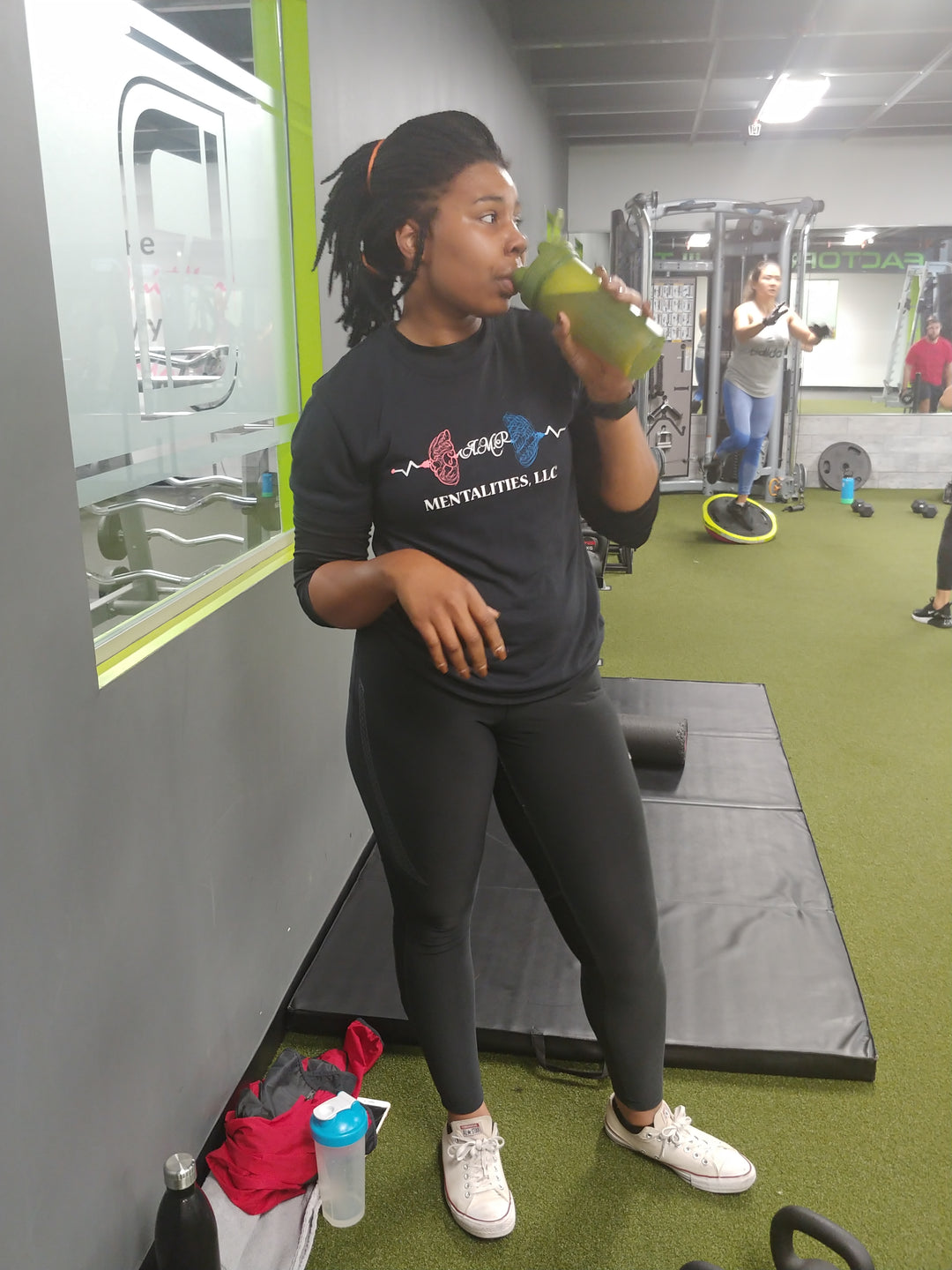 Te'Shawn Conley wearing the black "My Body Is My First Gym" Vintage T-Shirt in the gym. Posing while drinking water.