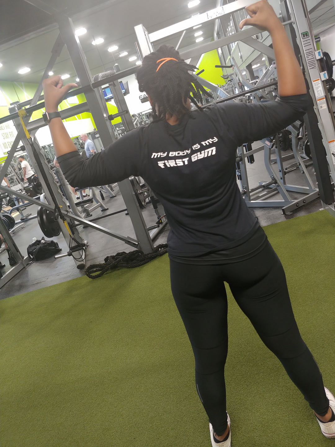 Te'Shawn Conley wearing the black "My Body Is My First Gym" Vintage T-Shirt in the gym, showing off the slogan.